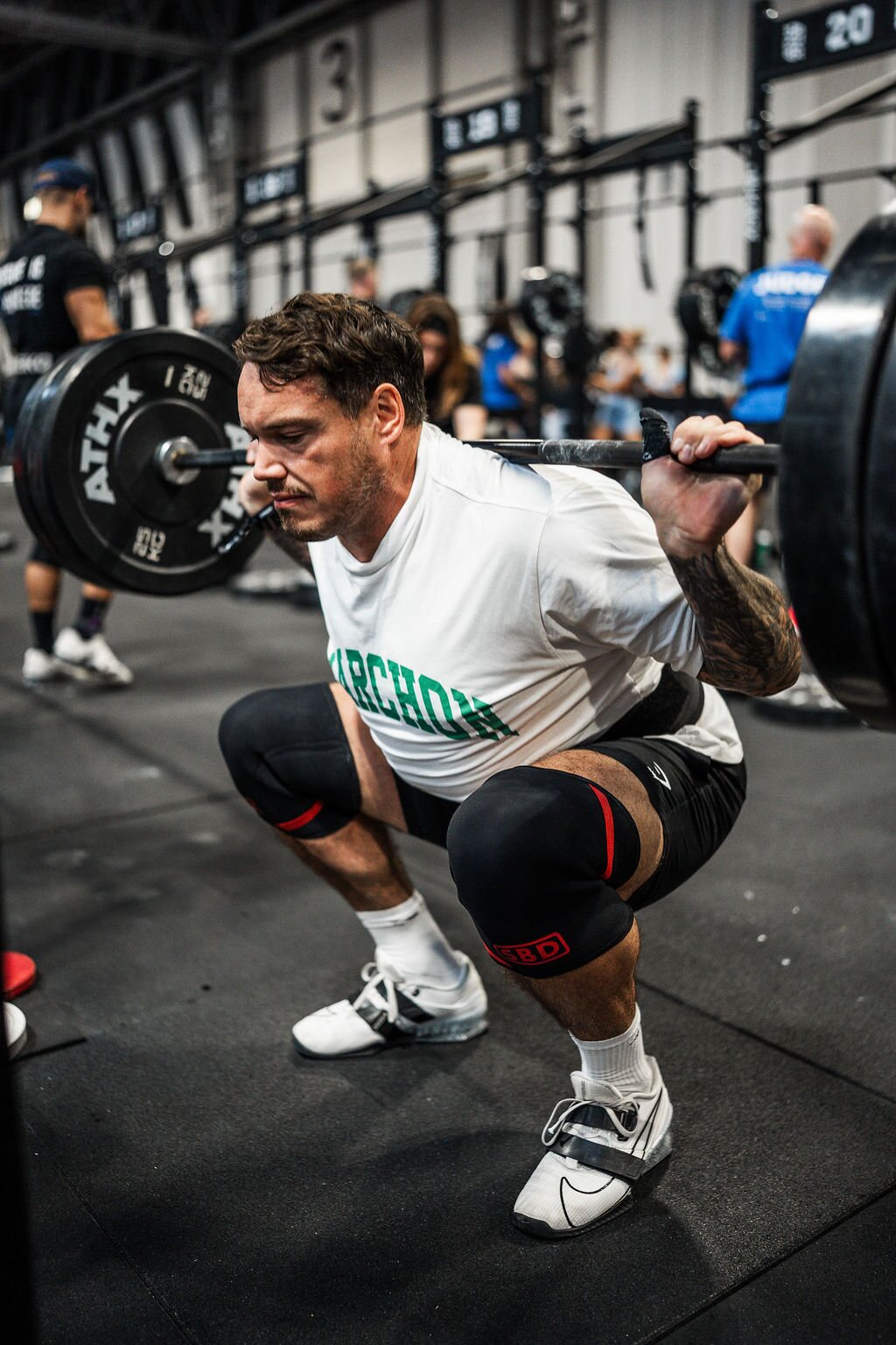 An athlete squats with a barbell on his back in the Strength Zone