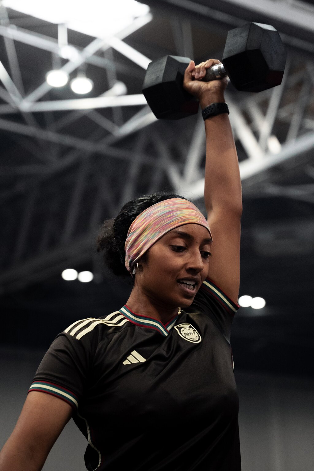 An athlete holds a dumbbell overhead in the MetCon X Zone