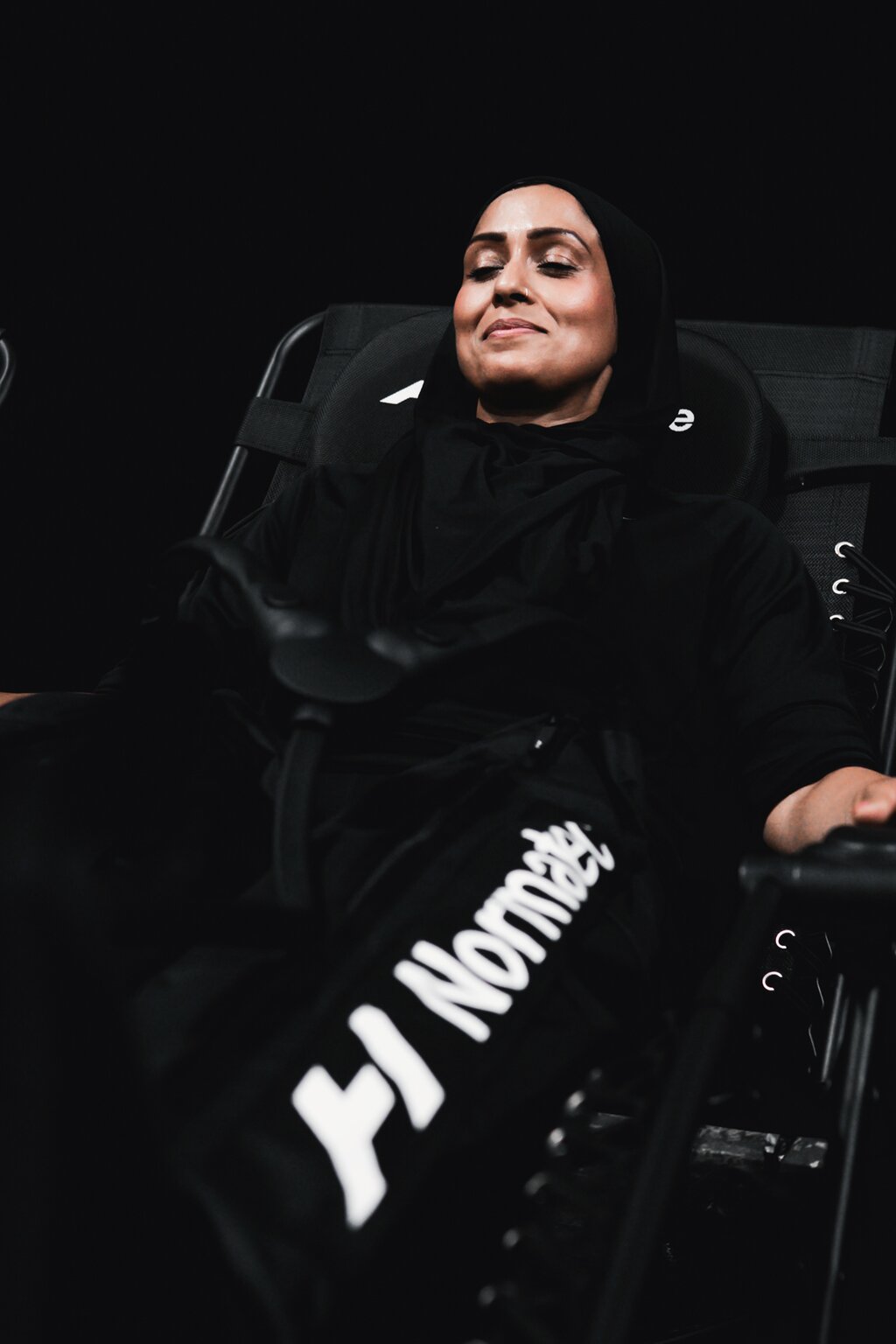 An athlete relaxes in compression boots in the Recovery Zone